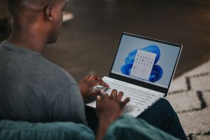 A man has an open laptop on his lap.