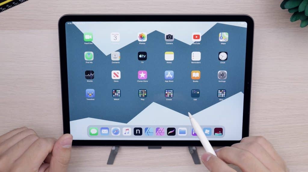 A smart tablet on a desk showing the home screen with apps.