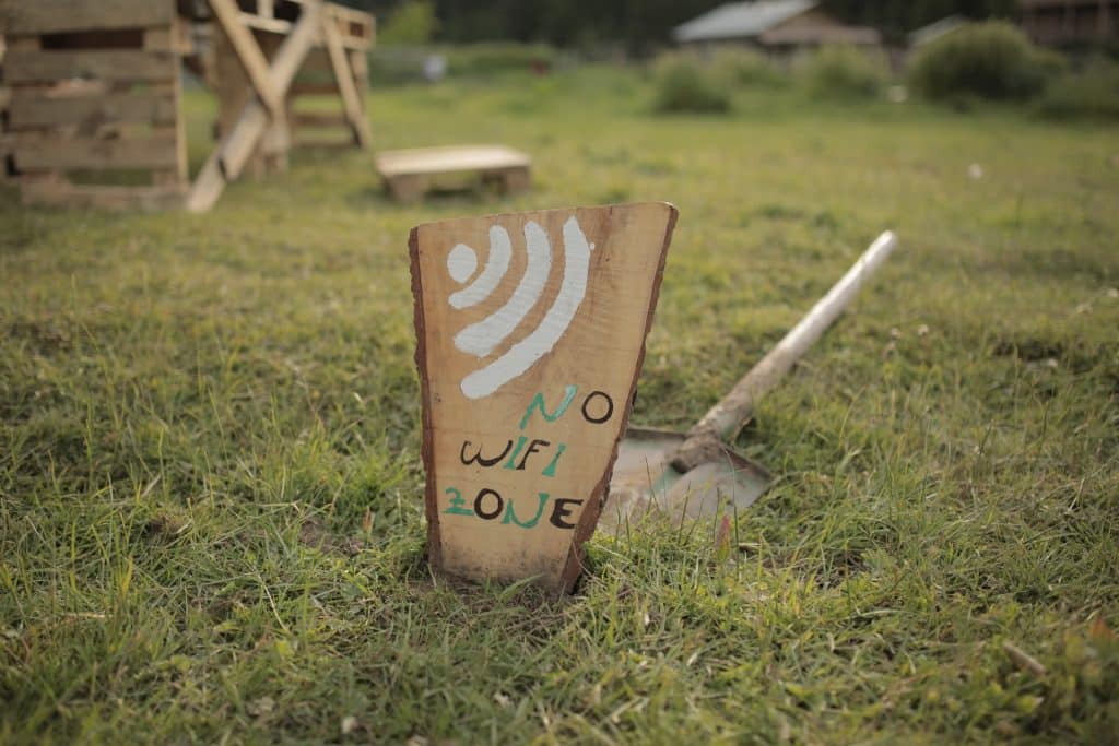 A lawn with a wooden sign dug into the dirt. The sign reads in childish lettering 'No Wifi zone', which is why using power apps offline is so essential