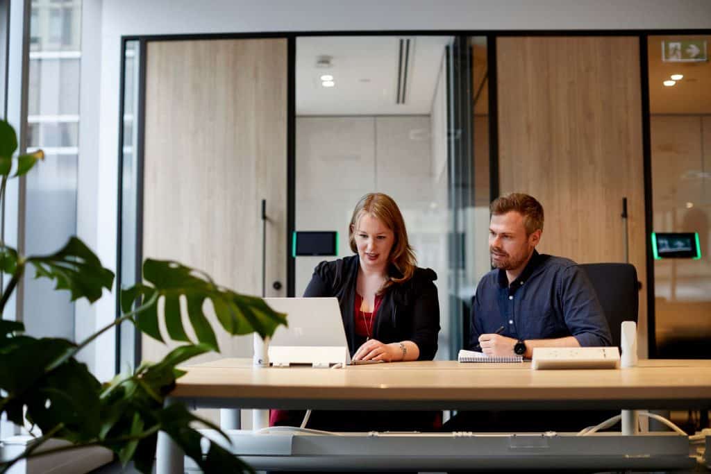 two colleagues sit side by side automating workflows with power automate