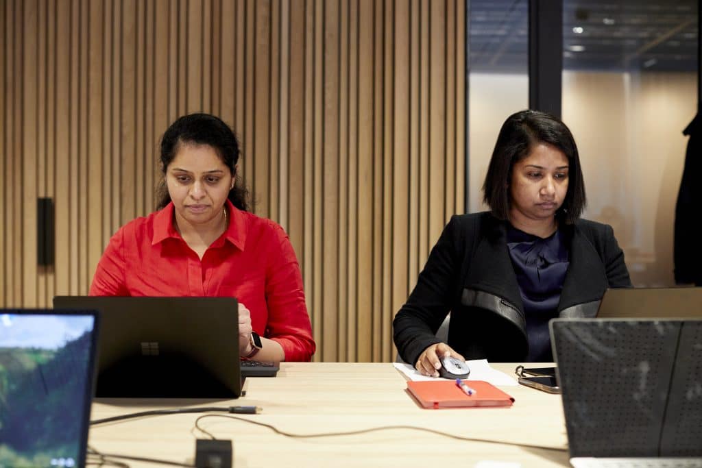 two people working on laptops, using the Microsoft 365 platform