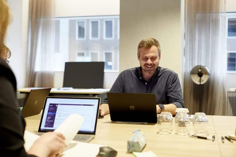 Man working at a laptop representing an employee engaging with SharePoint Online