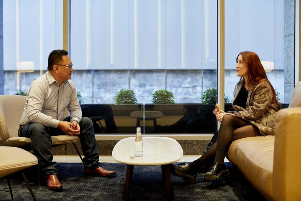 Man and woman discussing security in Microsoft SharePoint and Teams