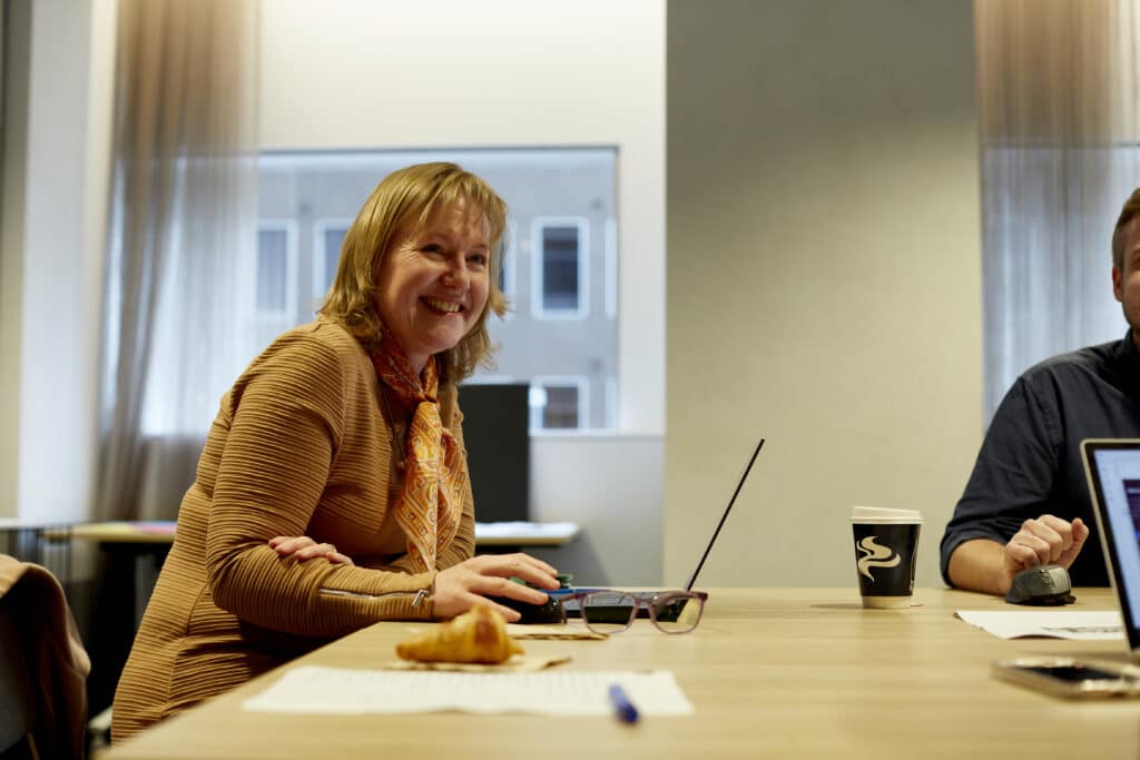 Happy employee sitting at a desk with laptop in front of her