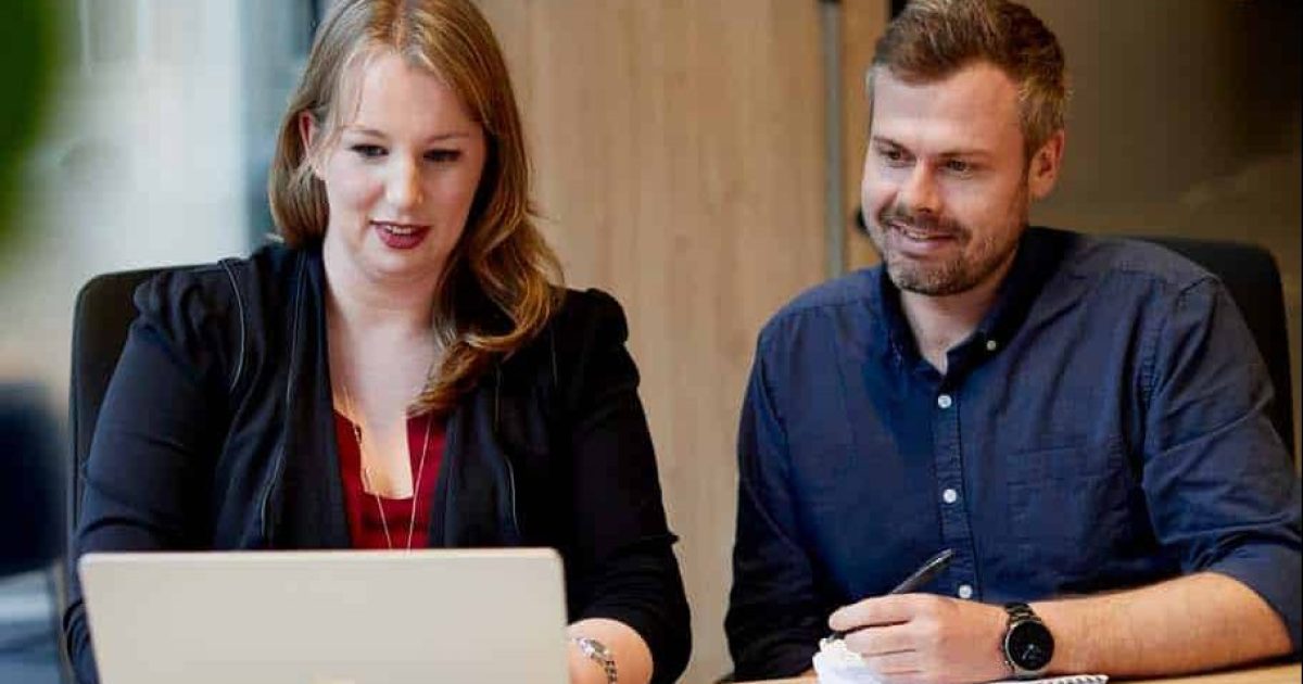 two colleagues sit side by side automating workflows with power automate