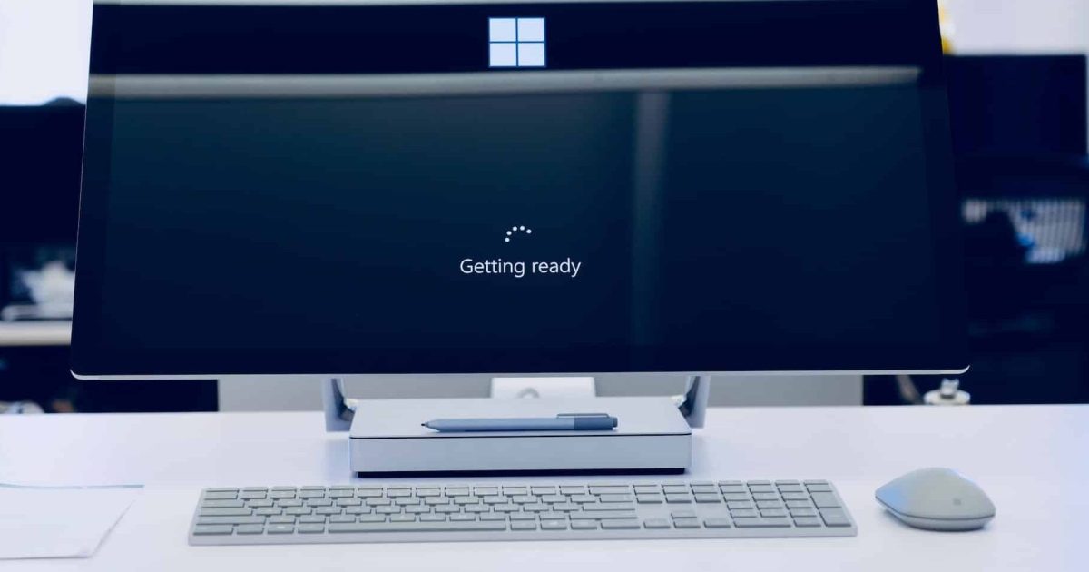 A close up of a computer monitor. A loading screen is in progress, the white microsoft symbol in the centre