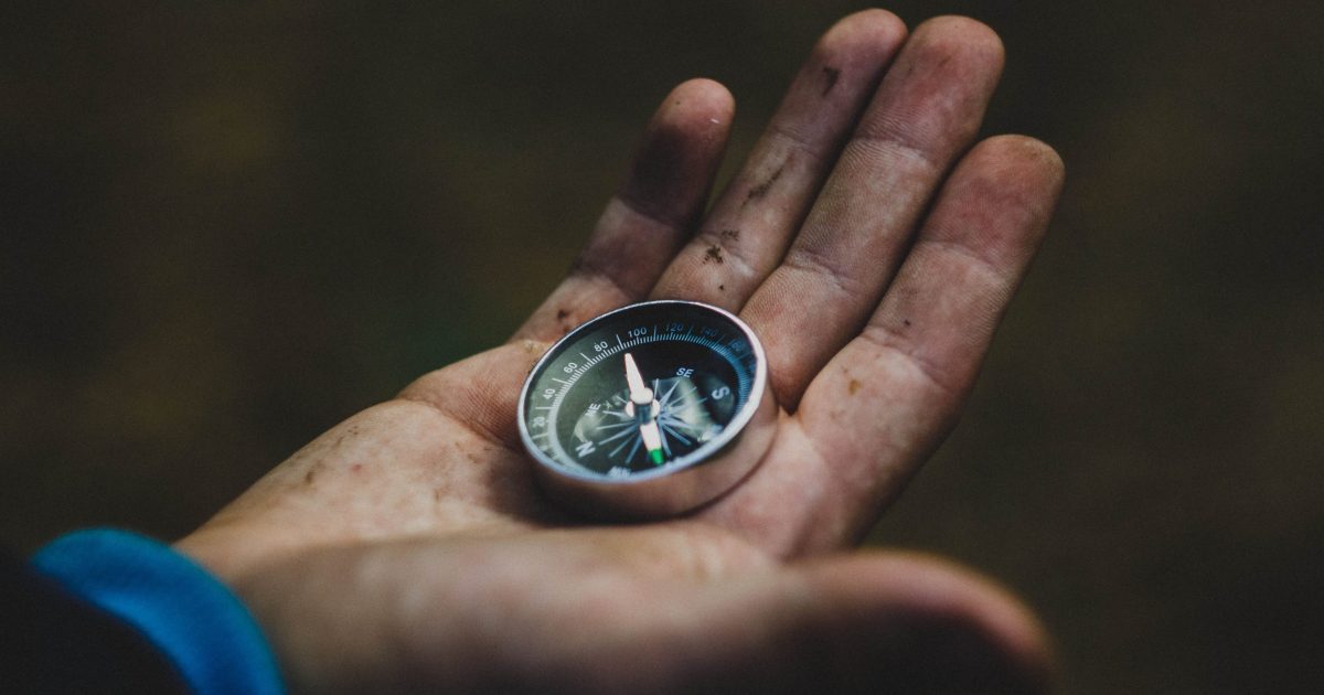 A dirty hand with a compass in the palm. Designing navigation for your intranet should follow similar intuition.