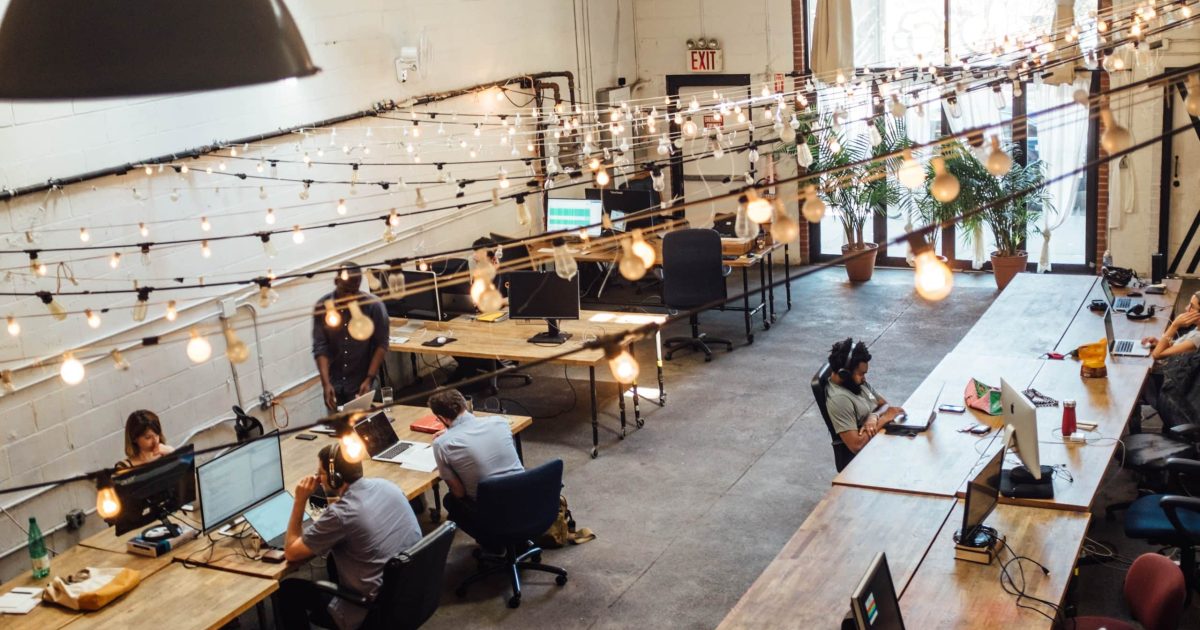 A spacious office, with timber desks and people working at computers and asking what is an intranet
