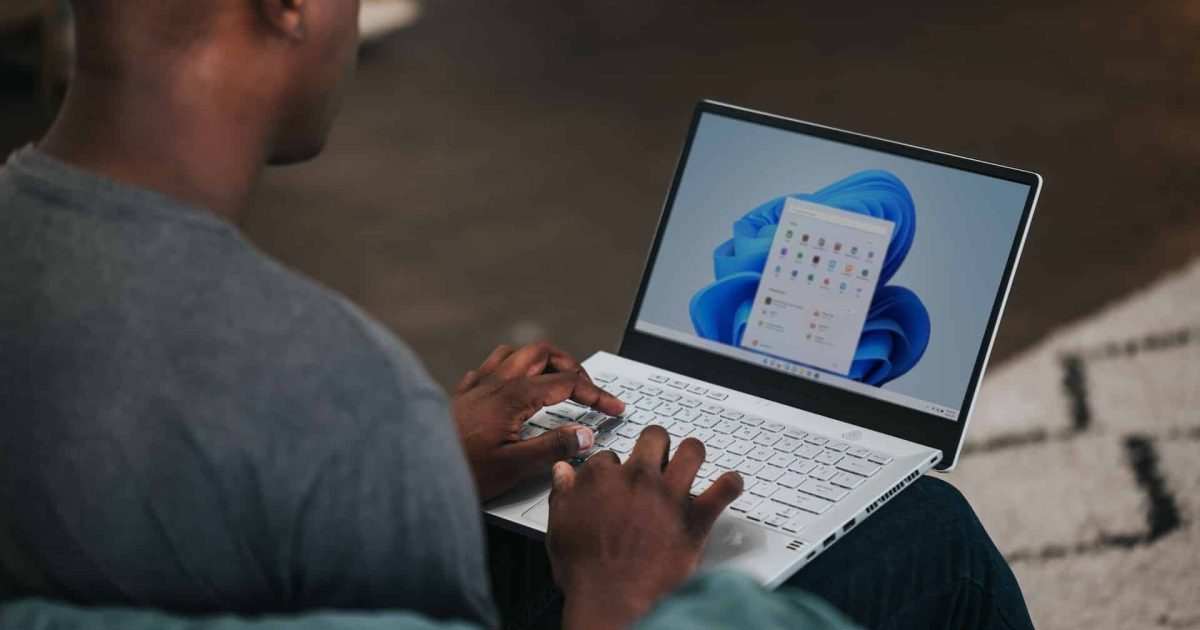 A man has an open laptop on his lap.
